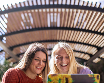 two women looking at computer, smiling and talking