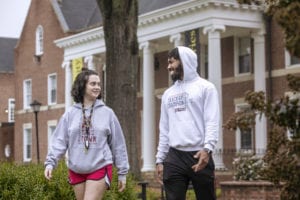 Male and female student talking and walking