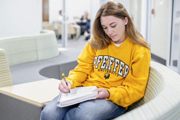 female student writing on notebook