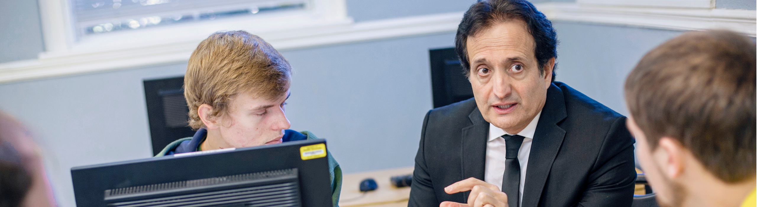 professor talking to students in computer lab