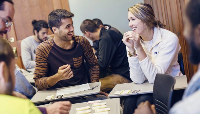 Group of students working together in class and smiling