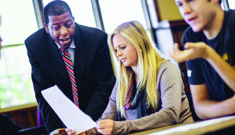 Professor helping student holding paper