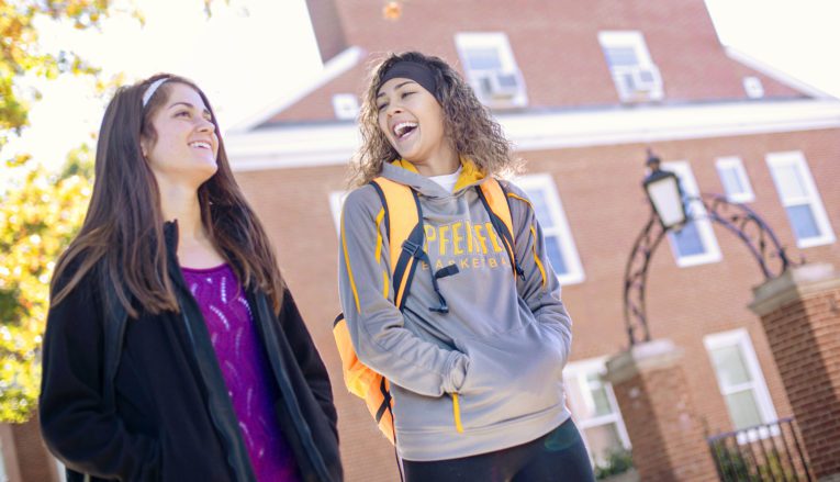 Two women walking outside on campus