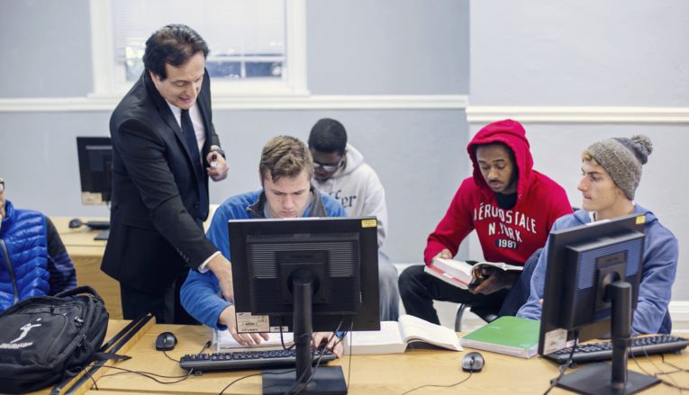 Professor talking to group of students in computer lab