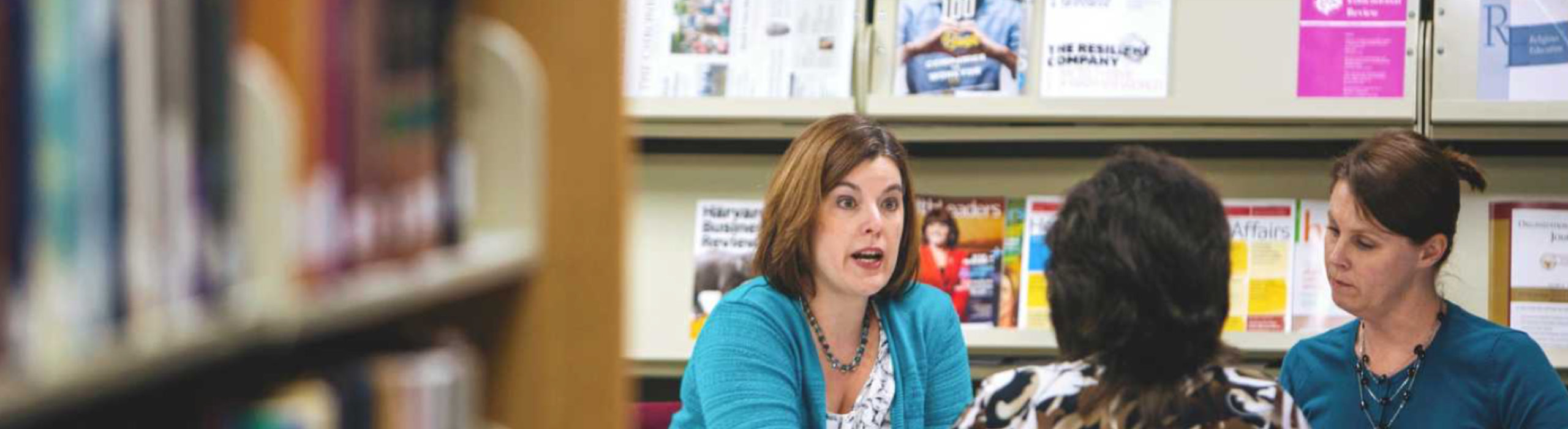 Instructor talking to students in library